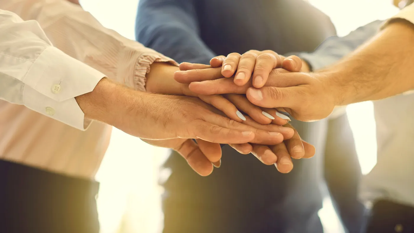 Team members joining hands